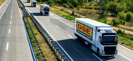 A convoy of white trucks with yellow and red DSE logos