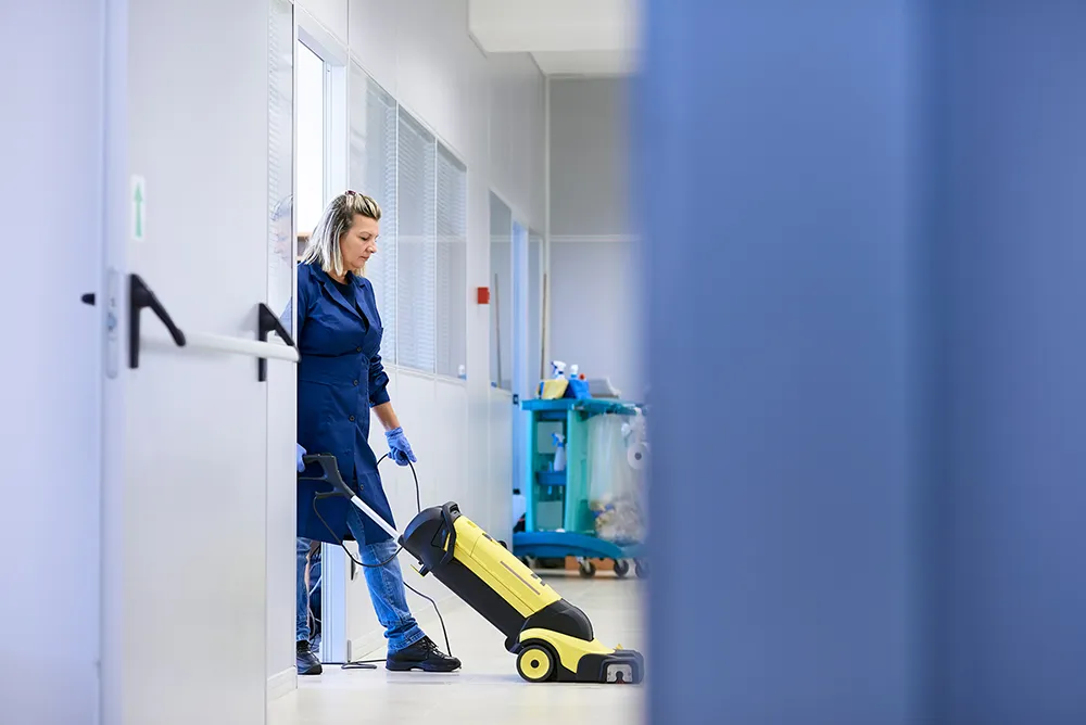 a cleaning lady with a commercial vacuum cleaner