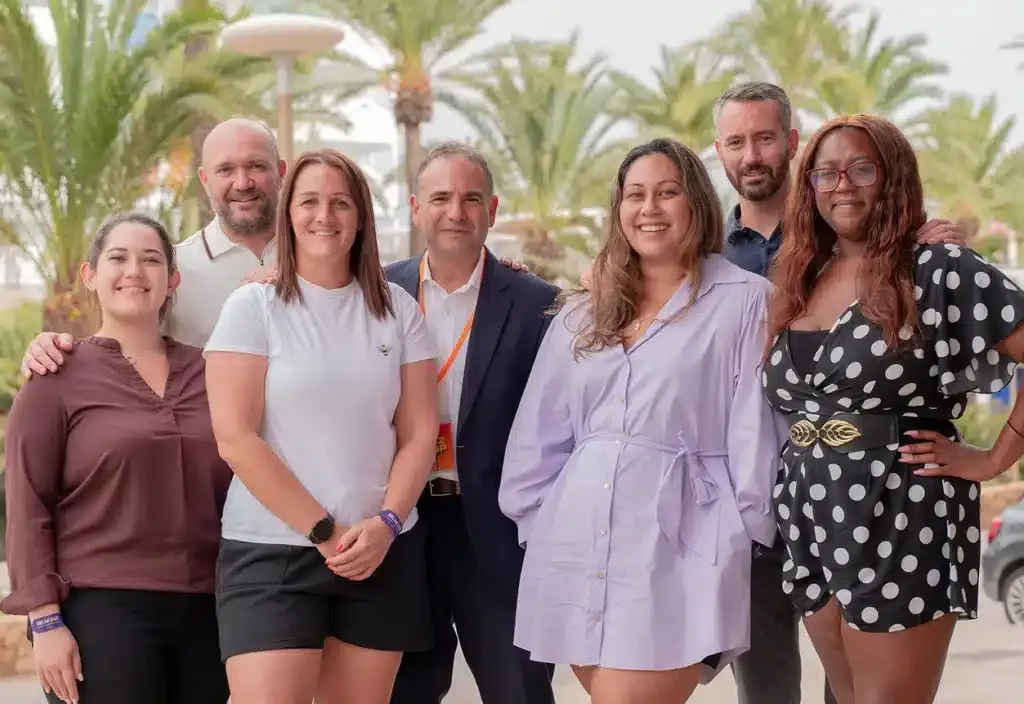 Appco UK team, smiling in front of palm trees