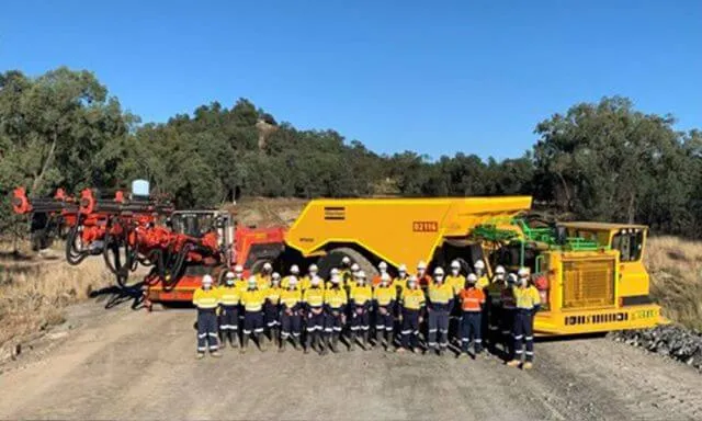 a group of workers in high vis and hard hats on a mining site