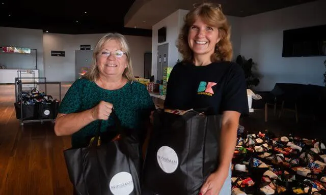 two ladies holding gift bags