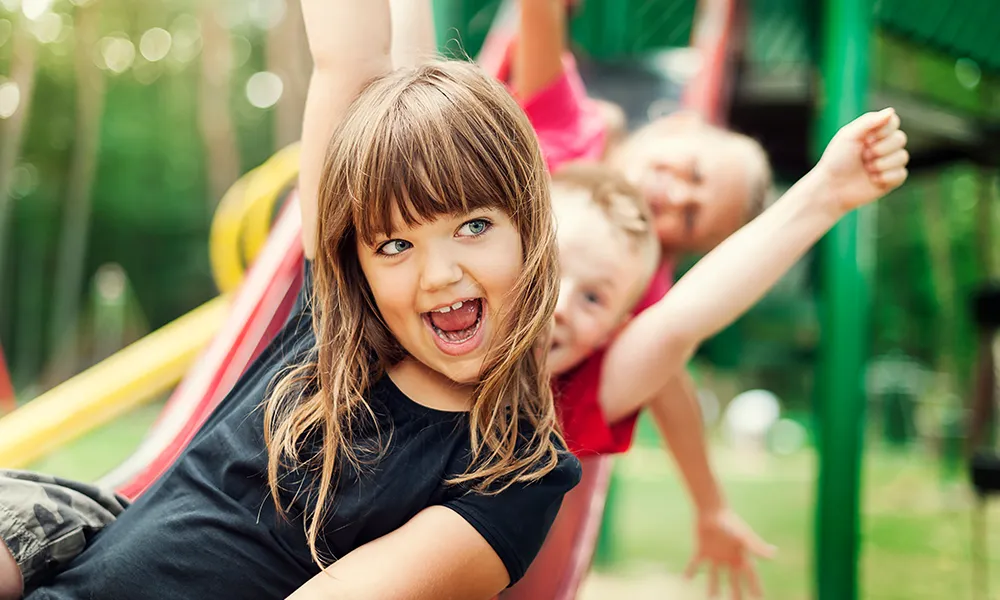 kids on a slide smiling