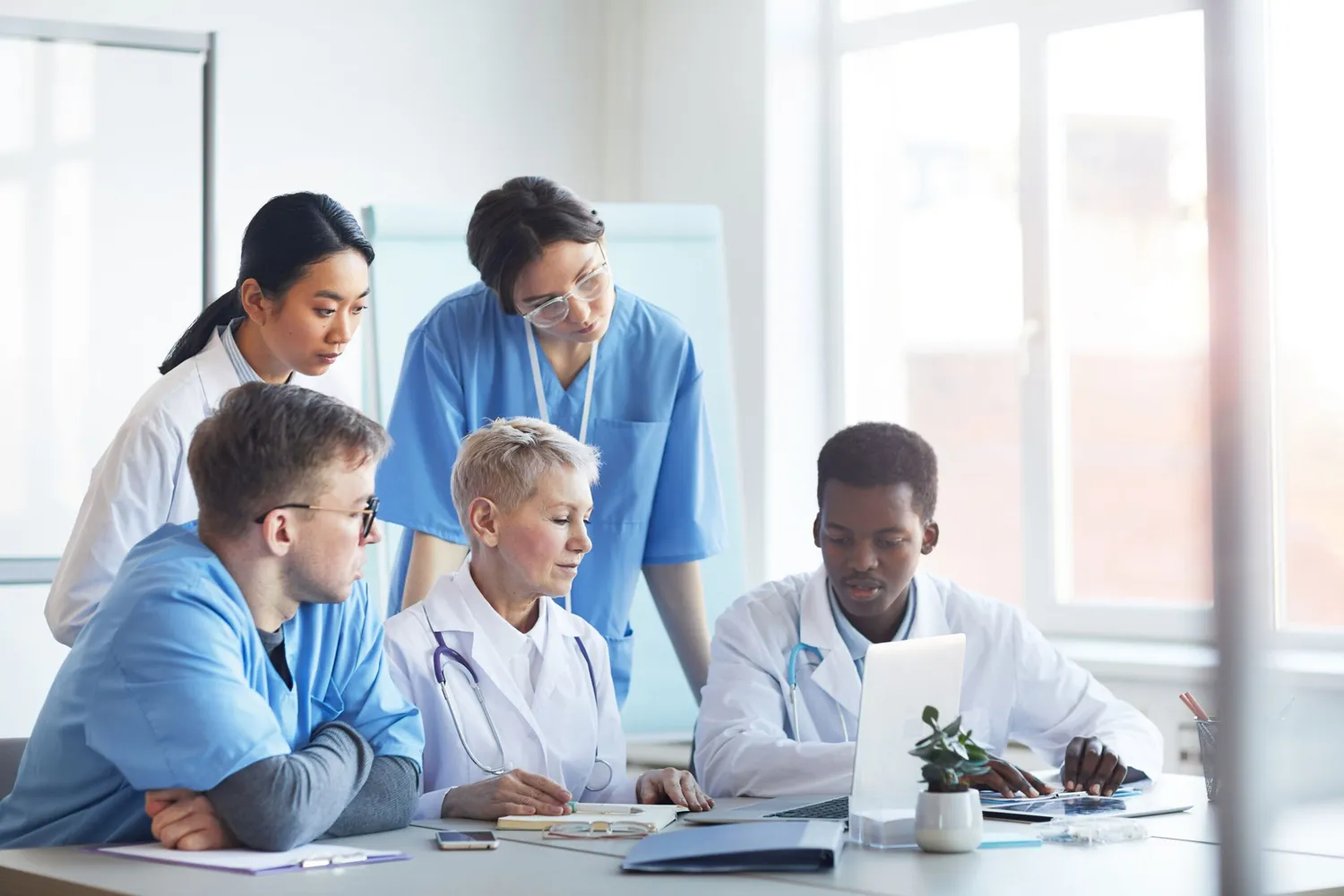 a group of doctors at the table looking at the screen