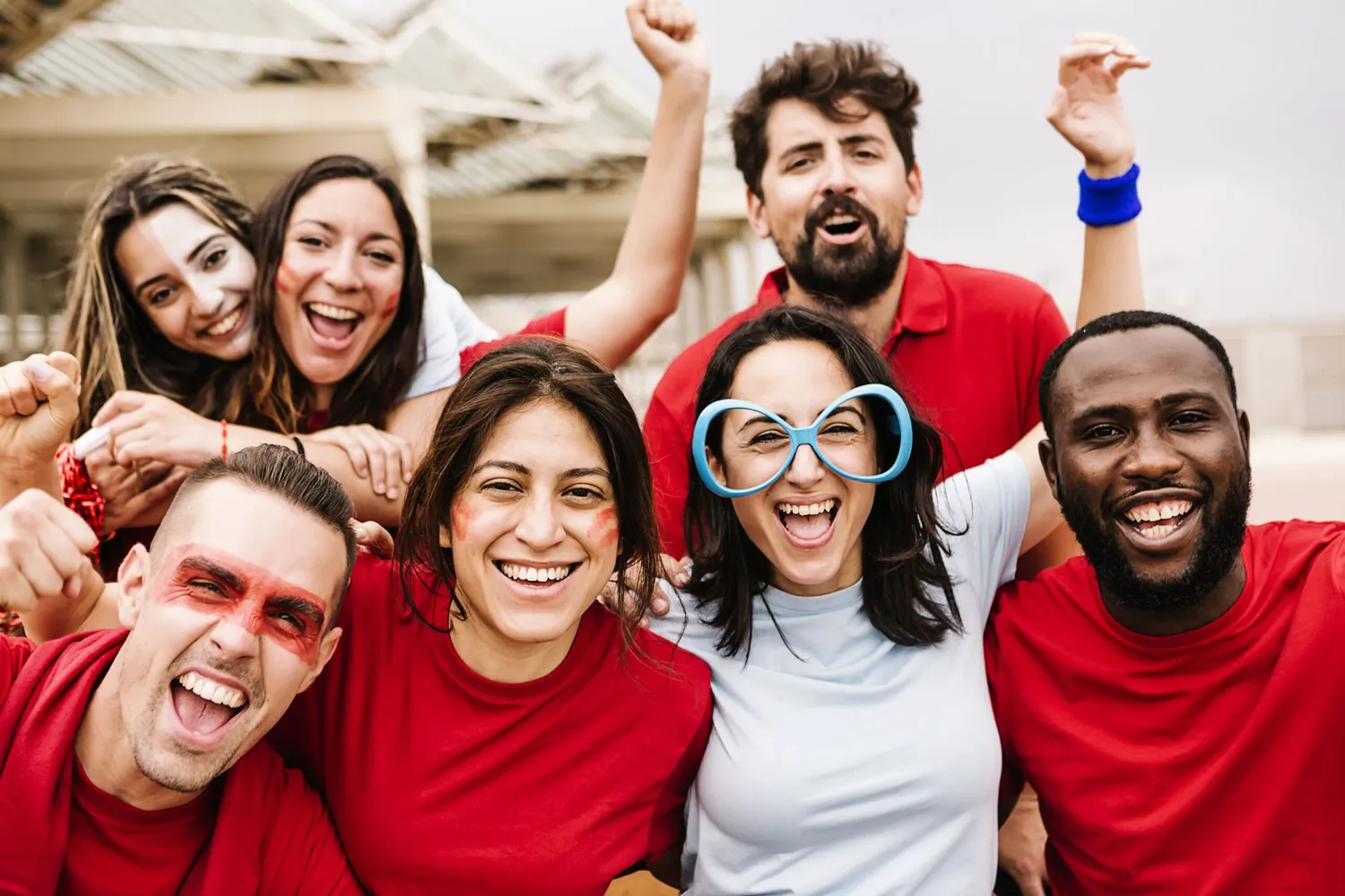 Multiracial group of spectators in team colors watching sports event at stadium - Sport entertainment and championship concept