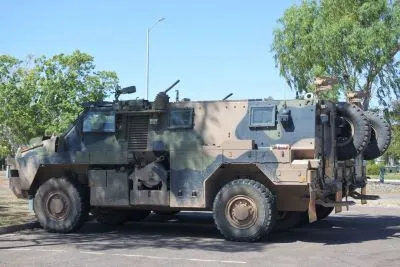 Camouflaged Bushmaster armoured vehicle parked in a carpark next to an eucalyptus tree. Image represents how Thales Group managed contractor onboarding.