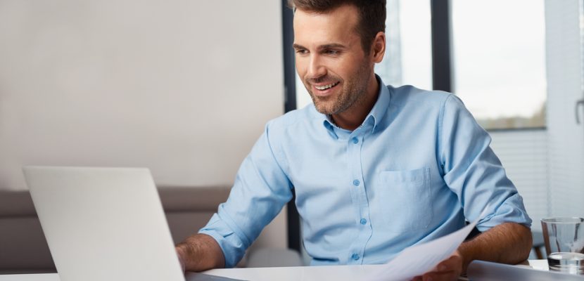 Man working on laptop from home. Counting financial data.